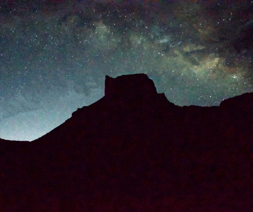 The Milky Way rises above Casa Grande's silhouette in the Chisos Basin at Big Bend National Park