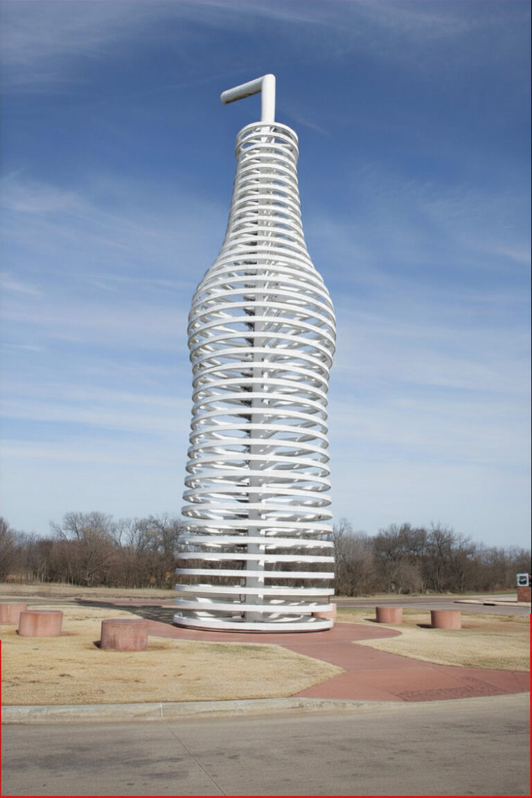 Large soda bottle sculpture at Pops in Arcadia, Oklahoma along Route 66 with open sky and surrounding grassy area