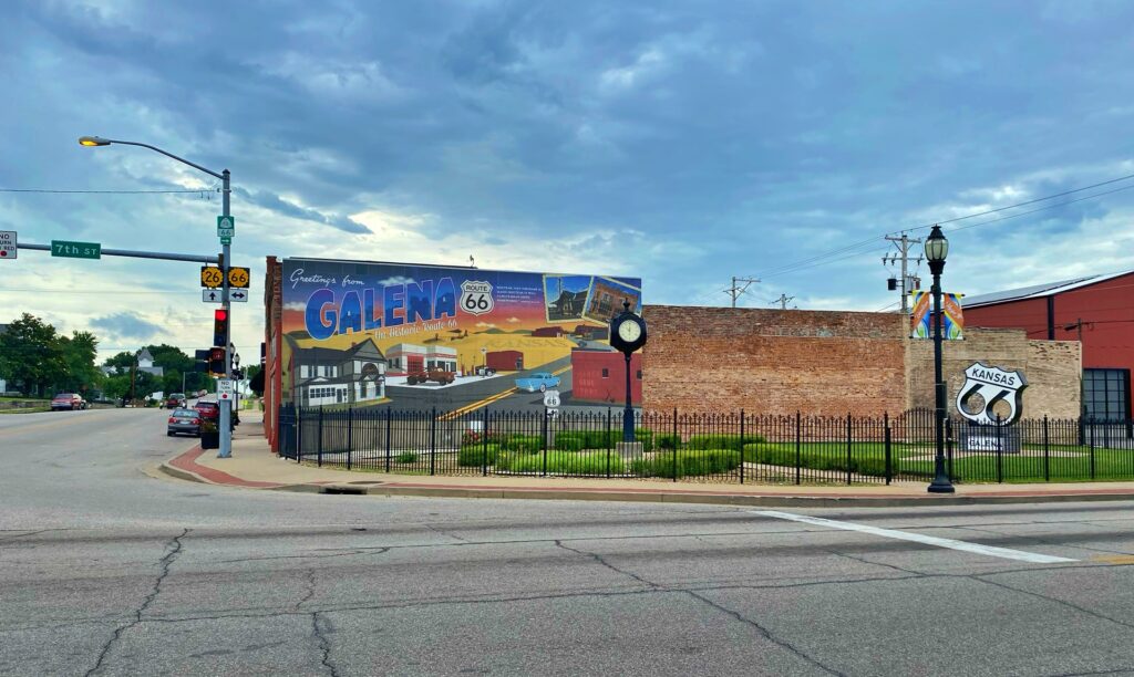 A large postcard-style mural reading "Greetings from Galena on Historic Route 66," depicting local landmarks, vintage cars, and a Route 66 shield