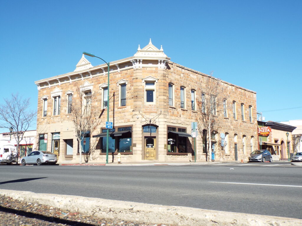 The historic sandstone Bank Hotel (McMillan Building) on the corner of Leroux Street and Route 66 in Flagstaff, Arizona, with "BANK" and "HOTEL" carved into its parapets