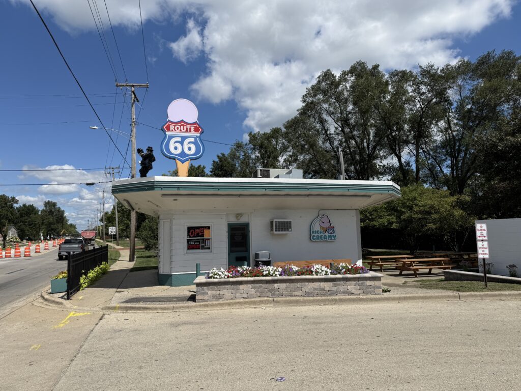 Rich & Creamy ice cream stand in Joliet, Illinois, with a large Route 66-themed ice cream cone sign on the roof and Blues Brothers statue figures on top of it