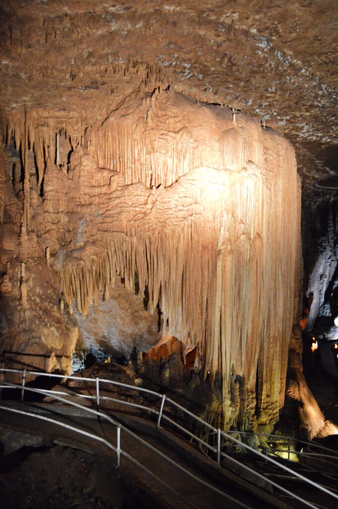 Massive stalactite drapery formation towering over the walkway at Blanchard Springs Caverns