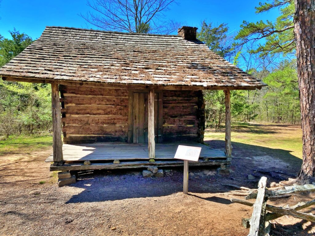 Historic 1857 log Pioneer Cabin with wood shingle roof and stone chimney at Petit Jean State Park, Arkansas