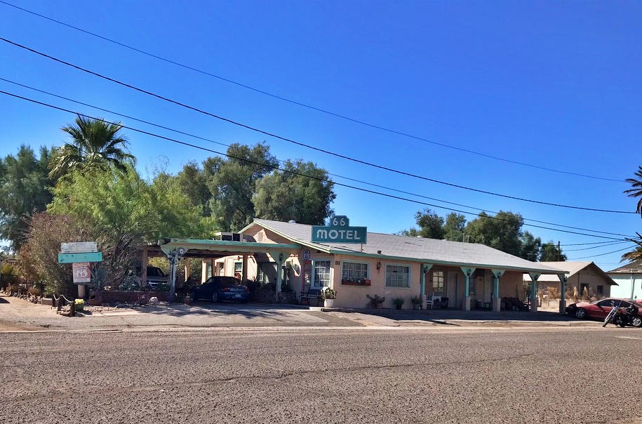 he pink and turquoise 66 Motel building in Needles, California, with its original sign and covered carport, along Route 66