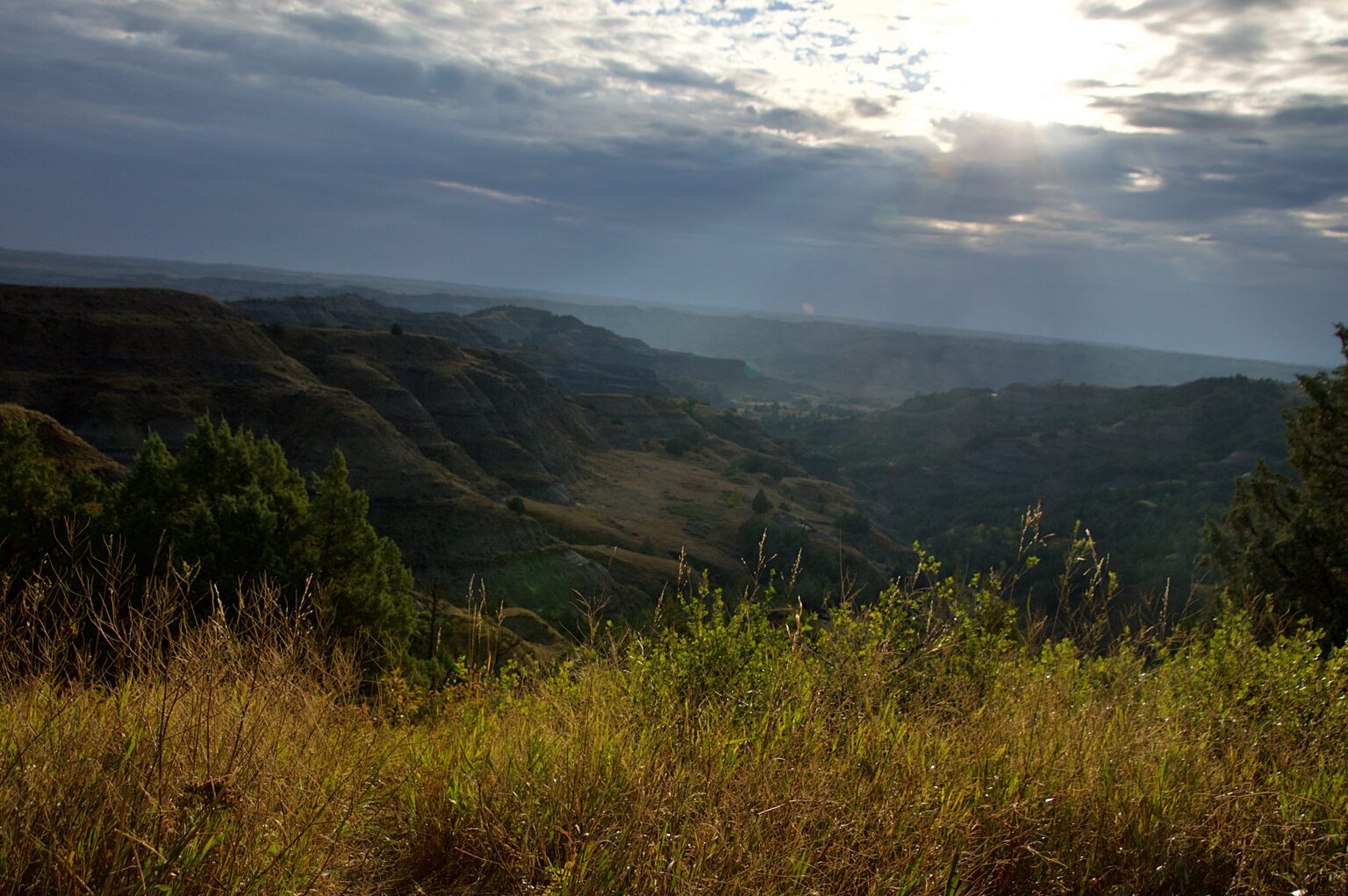 Sunrise breaking through storm clouds over the badlands in Theodore Roosevelt National Park's North Unit